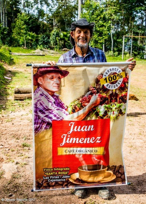 L'agricultor membre de Cenfrocafe Juan Jiménez sostenint un pòster per al seu cafè orgànic de comerç just L'agricultor membre de Cenfrocafe Juan Jiménez sostenint un pòster per al seu cafè orgànic de comerç just